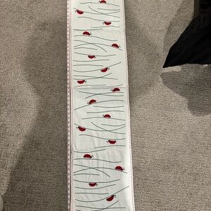 White table runner with ladybug design also includes two place settings